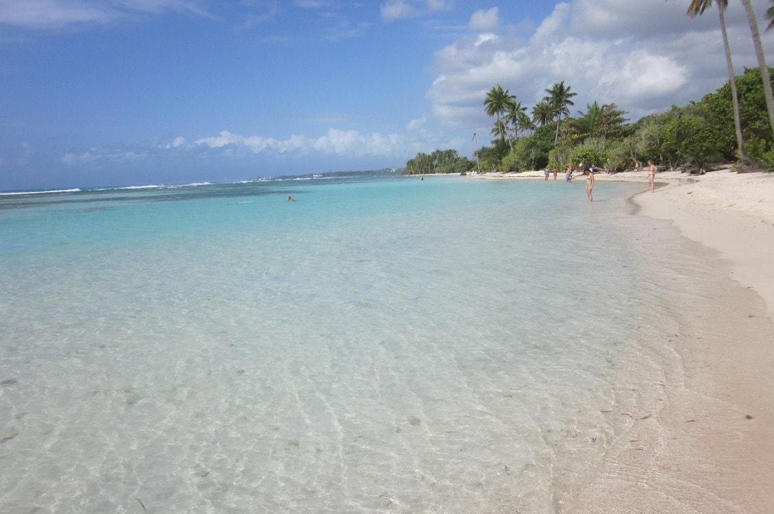 Plage de sable blanc et d'eau turquoise dans les Caraïbes